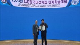 한국버섯학회 하계학술대회에서 학술상을 수상하여 2명의 남자가 무대에 올라가 수상식을 하는 모습을 담은 사진