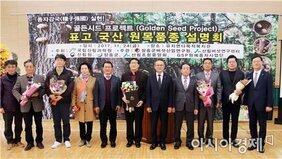  장흥군의회 김복실 의장, 장흥군 위삼섭 부군수, 제해신 버섯산업연구원장과 국립산림과학원 최돈하 전문위원, 산림버섯연구센터 이재현 센터장, 장흥표고버섯생산자연합회 윤용진 회장과 여러 사람들이 꽃을 들고 앞에 나와 표고 국산 원목품종 설명회 개최를 기념하는 모습을 담은 사진