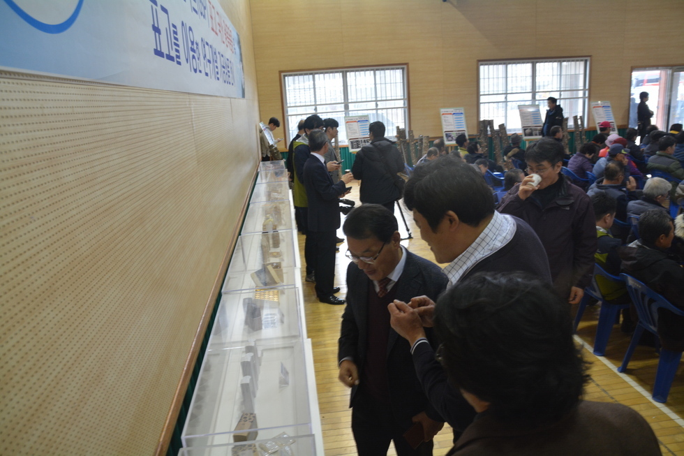 유치면 다목적회관에 전시된 버섯관련 상품들을 둘러보고 있는 사람들