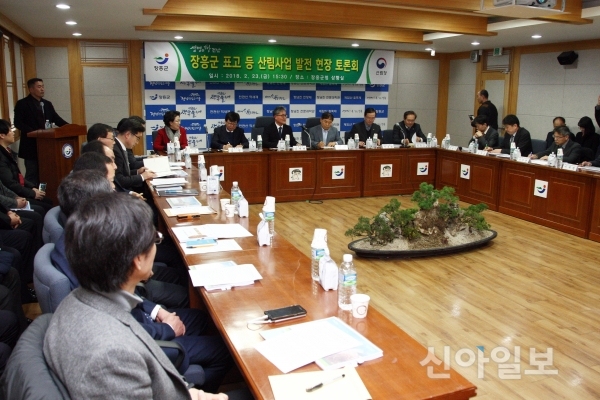 왼쪽에는 남자 진행자와 그리고 좌우 가운데 여러 사람들이 둘러 앉아 장흥군 표고 등 산림사업 발전 현장 토론회를 진행하는 모습을 담은 사진