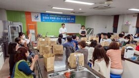 제빵교육 강의실에서 교육 강사가 앞에 나와 있고 20명의 수강생들이 자리에 앉아 개강식을 하는 모습을 담은 사진